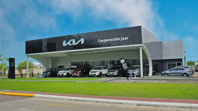 Un concesionario Kia dentro de un centro comercial en Choluteca Honduras, con varios autos Kia estacionados afuera.