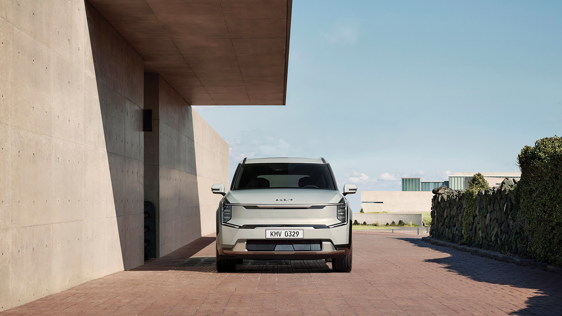 Vista frontal del Kia EV9 estacionado junto a un edificio
